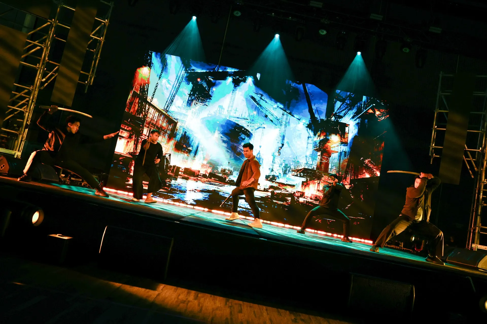 Action performers on the TCX 2026 main stage with a large visual backdrop and show lighting.