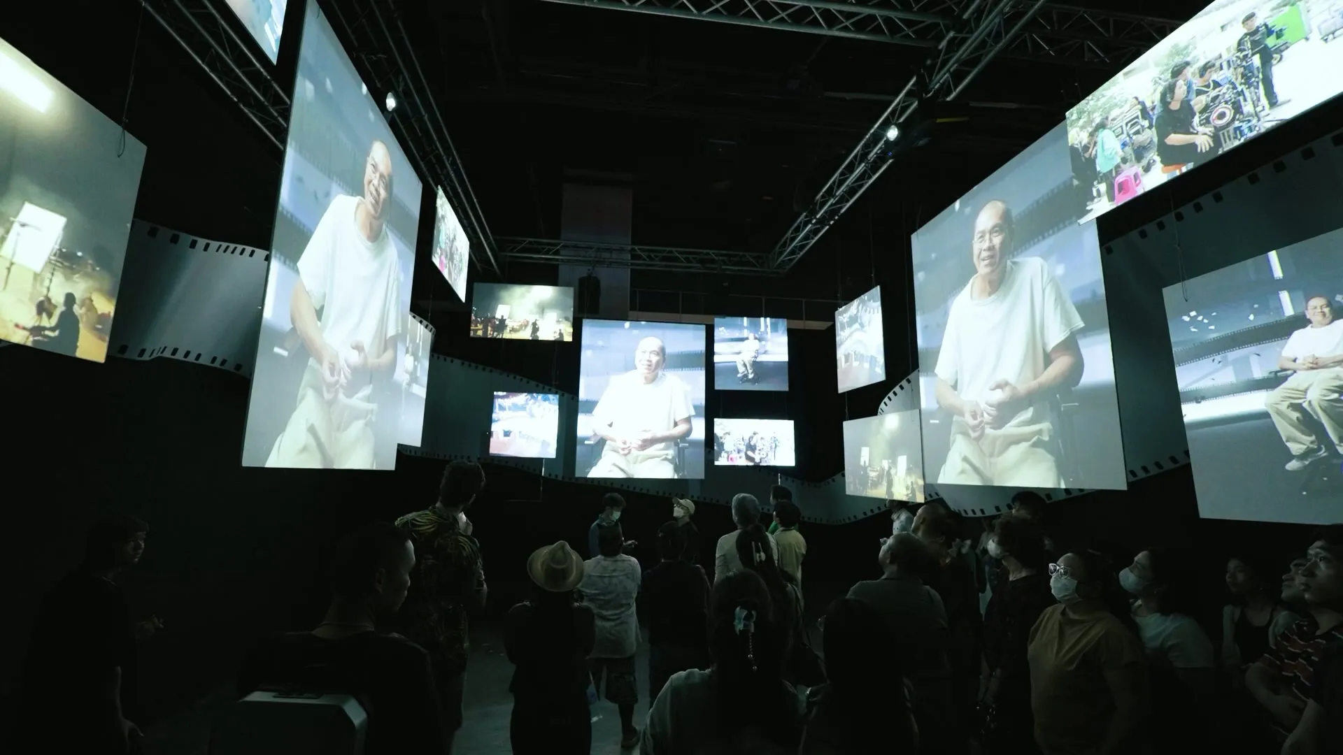 Visitors inside the installed TCX 2025 multiscreen cinema tribute space.