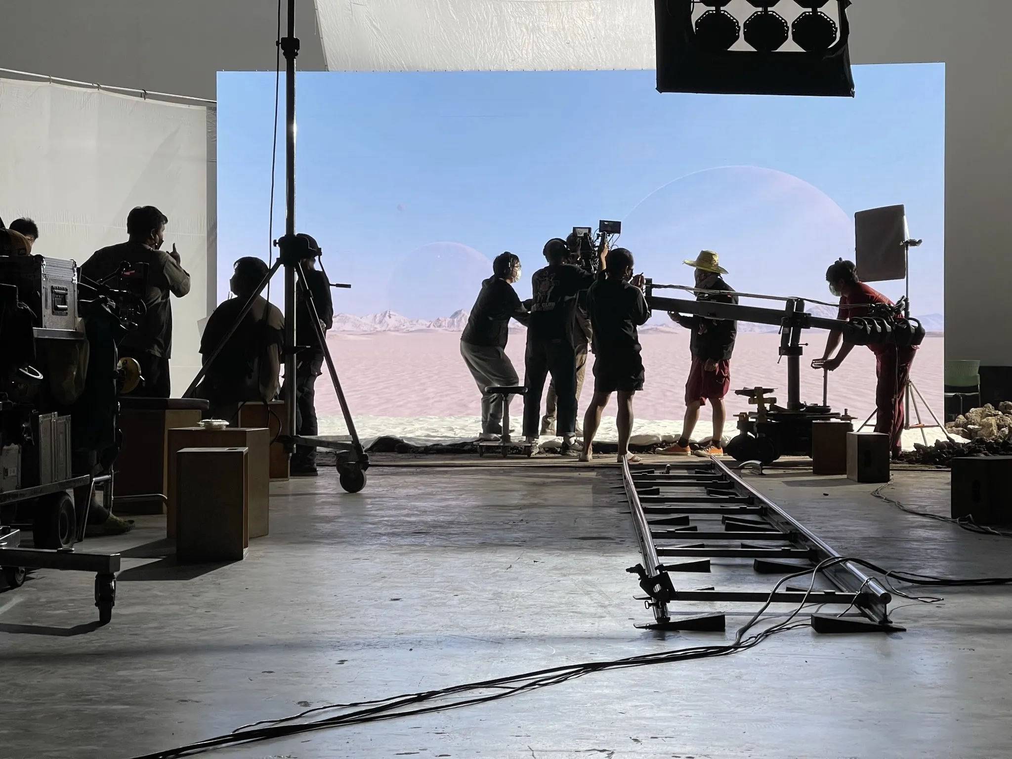 Camera crew working in front of the pale desert LED environment on the ATLAS set